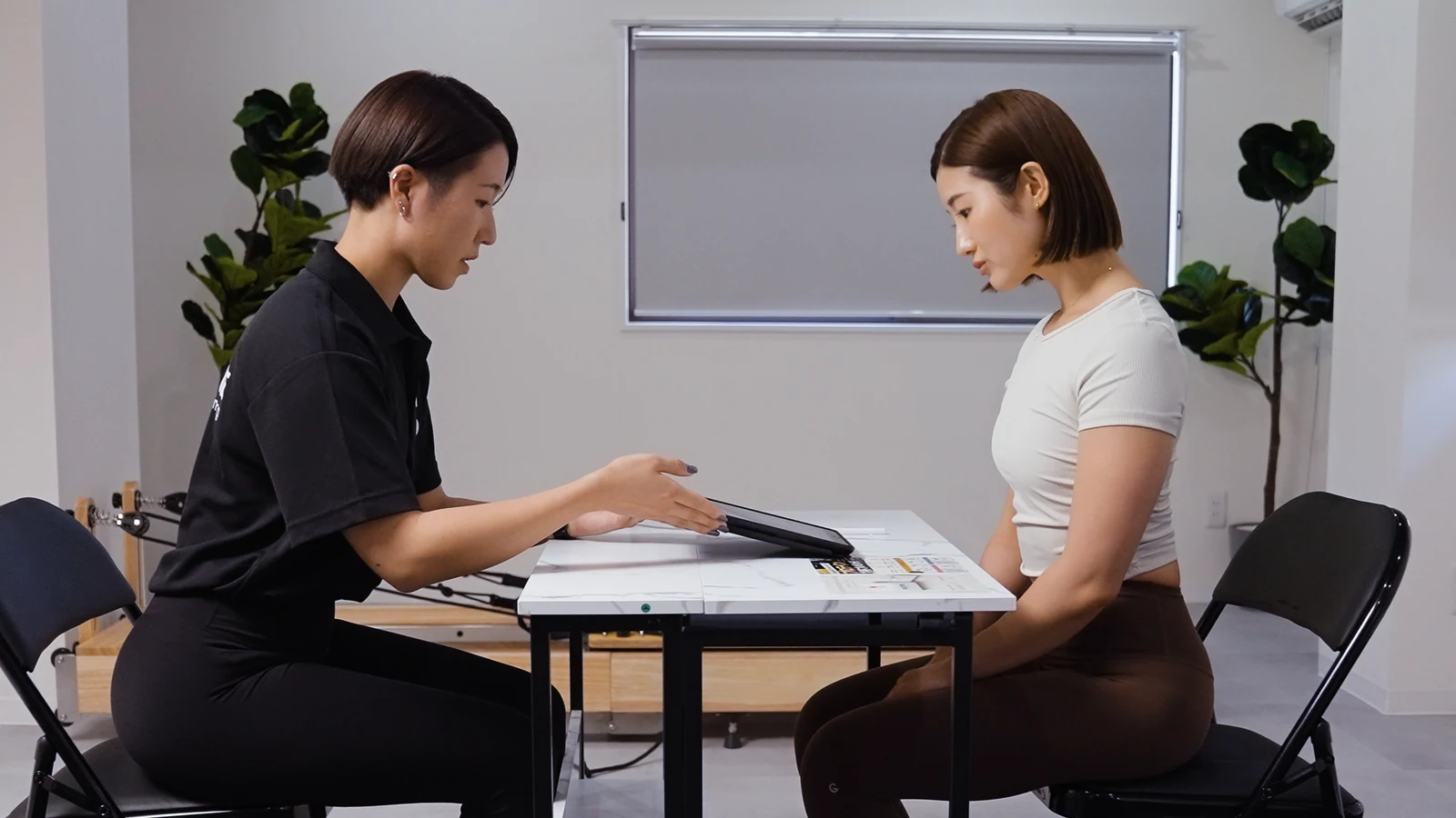 女性トレーナーと利用者が向かい合って相談する様子